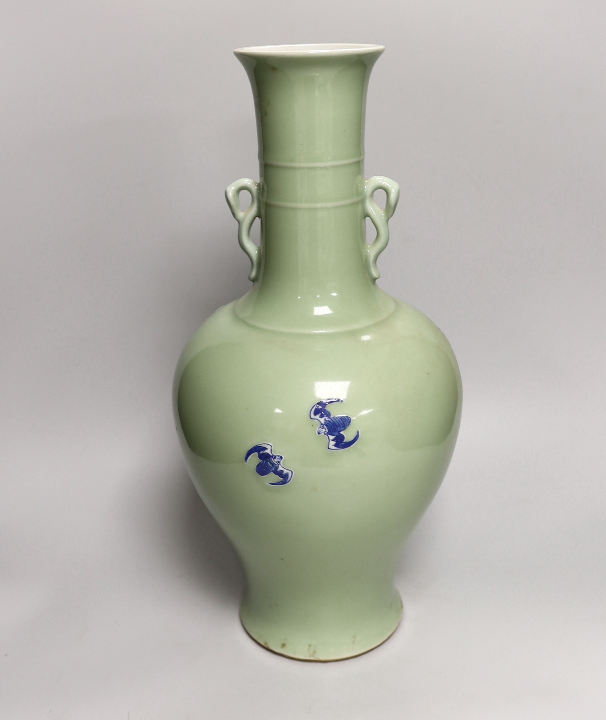 A large Chinese celadon glazed vase with twin handles, decorated in relief with figures and bats, 37cm high